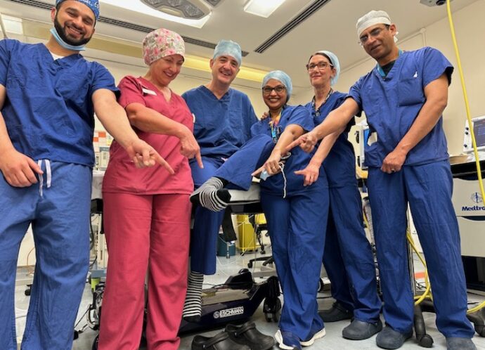 Surgeons in scrubs wearing stripy socks for rare disease day